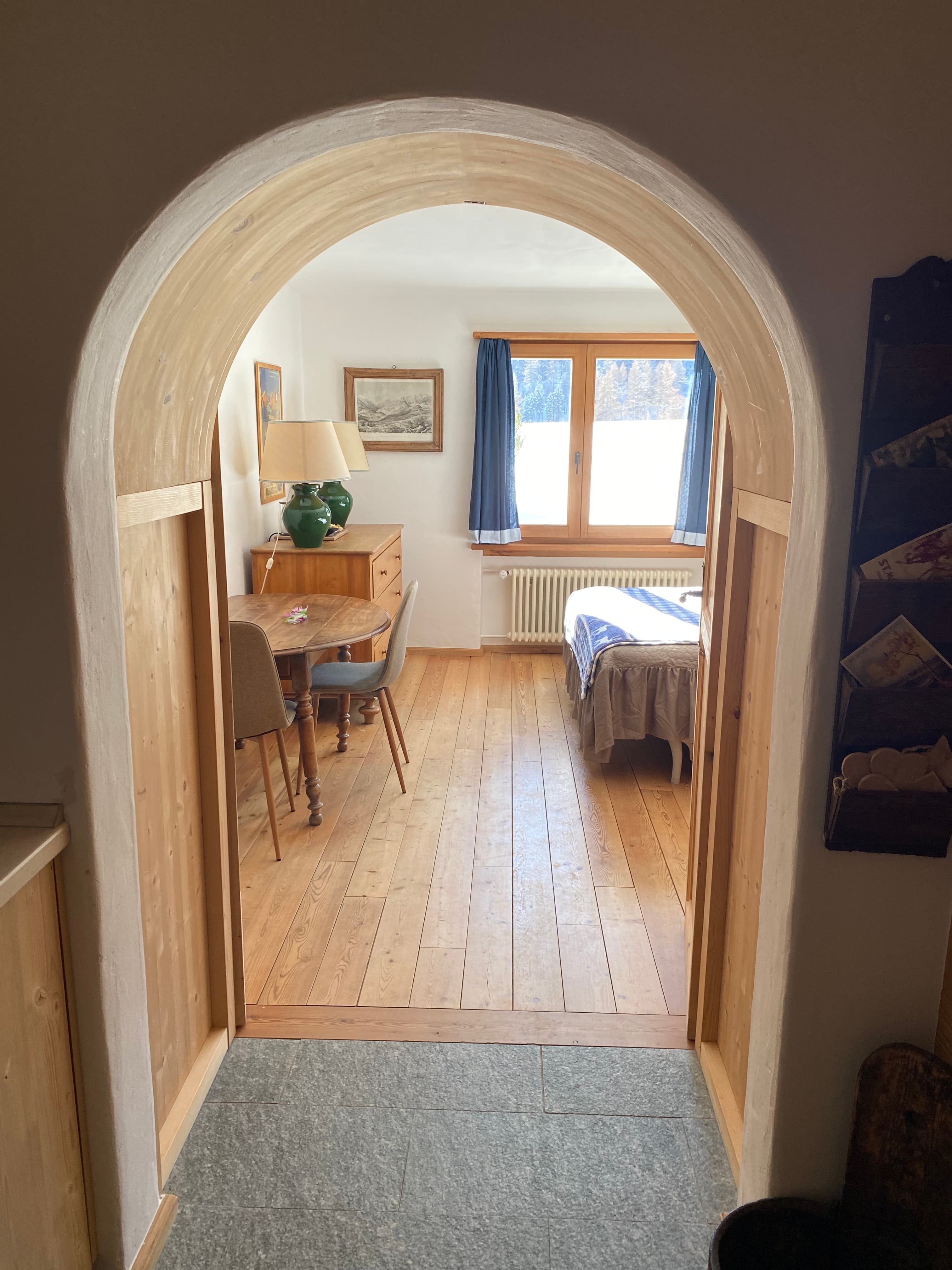 Cozy room through pine wood archway